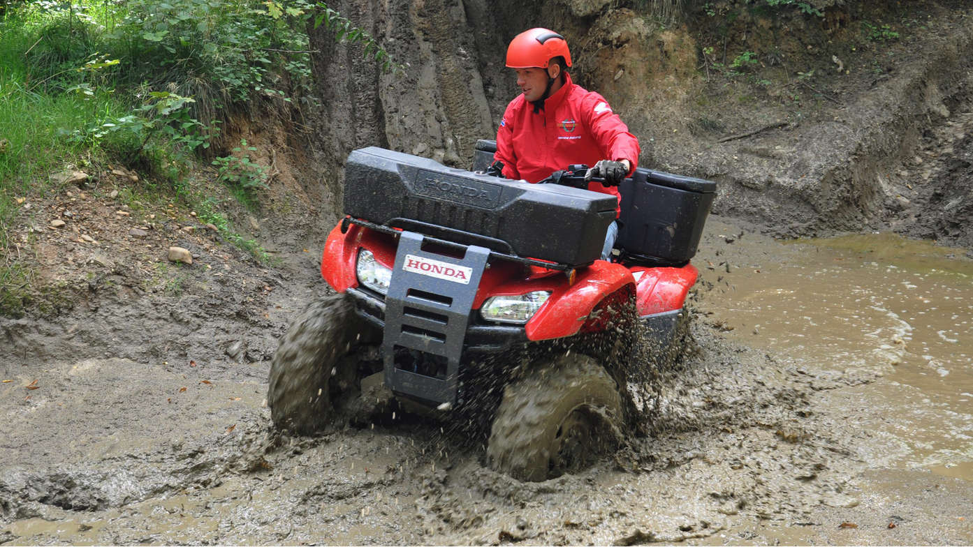 Fourtrax 420 being used by model, shallow stream location.