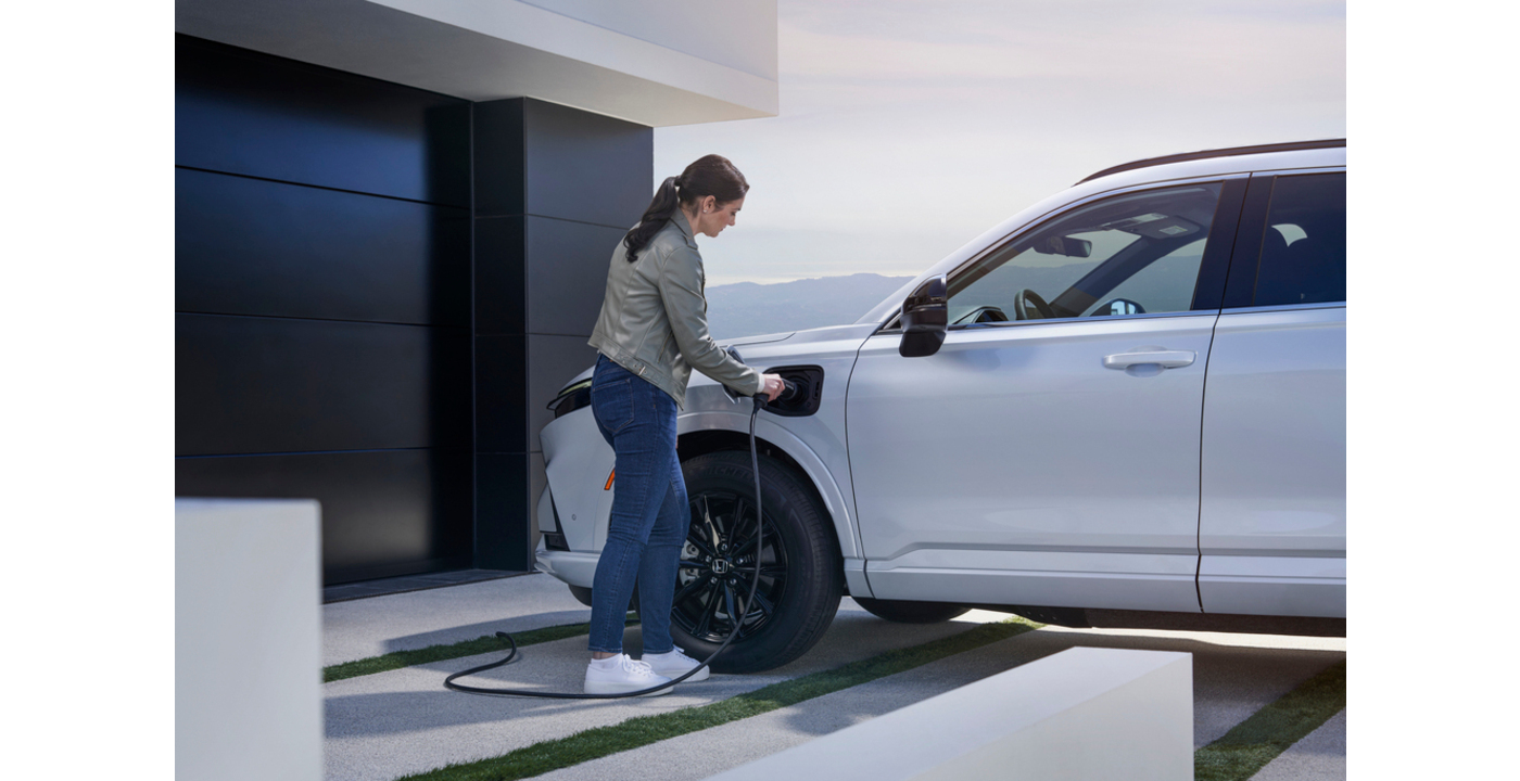 a woman connecting her Honda electric car to charge