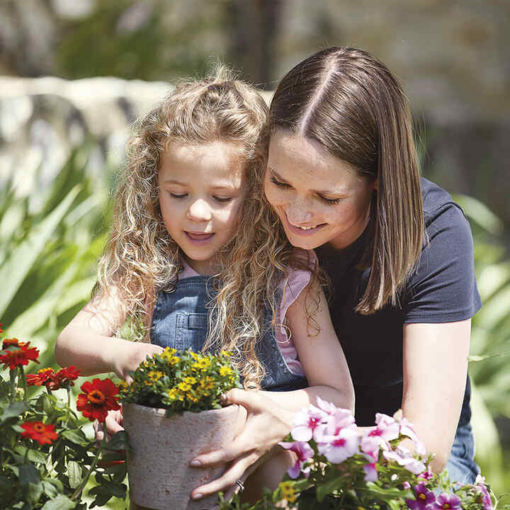 Mother and daughter planting flowers.