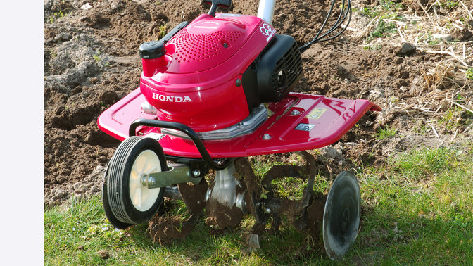 Close up of mini tiller, garden location.