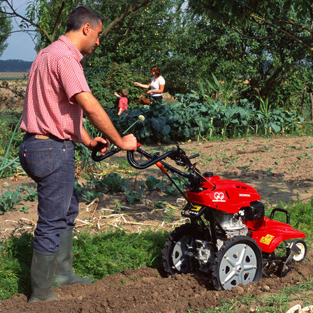 Rotary tiller, being used by model, garden location.