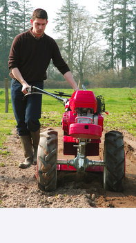 Versatile tiller, being used by model, garden location.