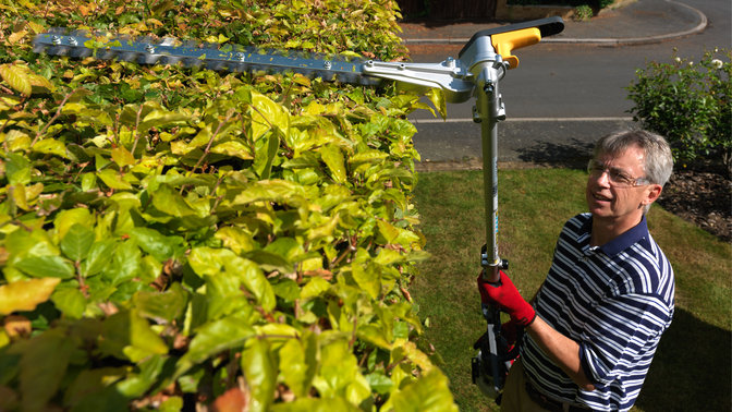 Honda Versatool with hedgetrimmers attachment, being used by model, garden location.