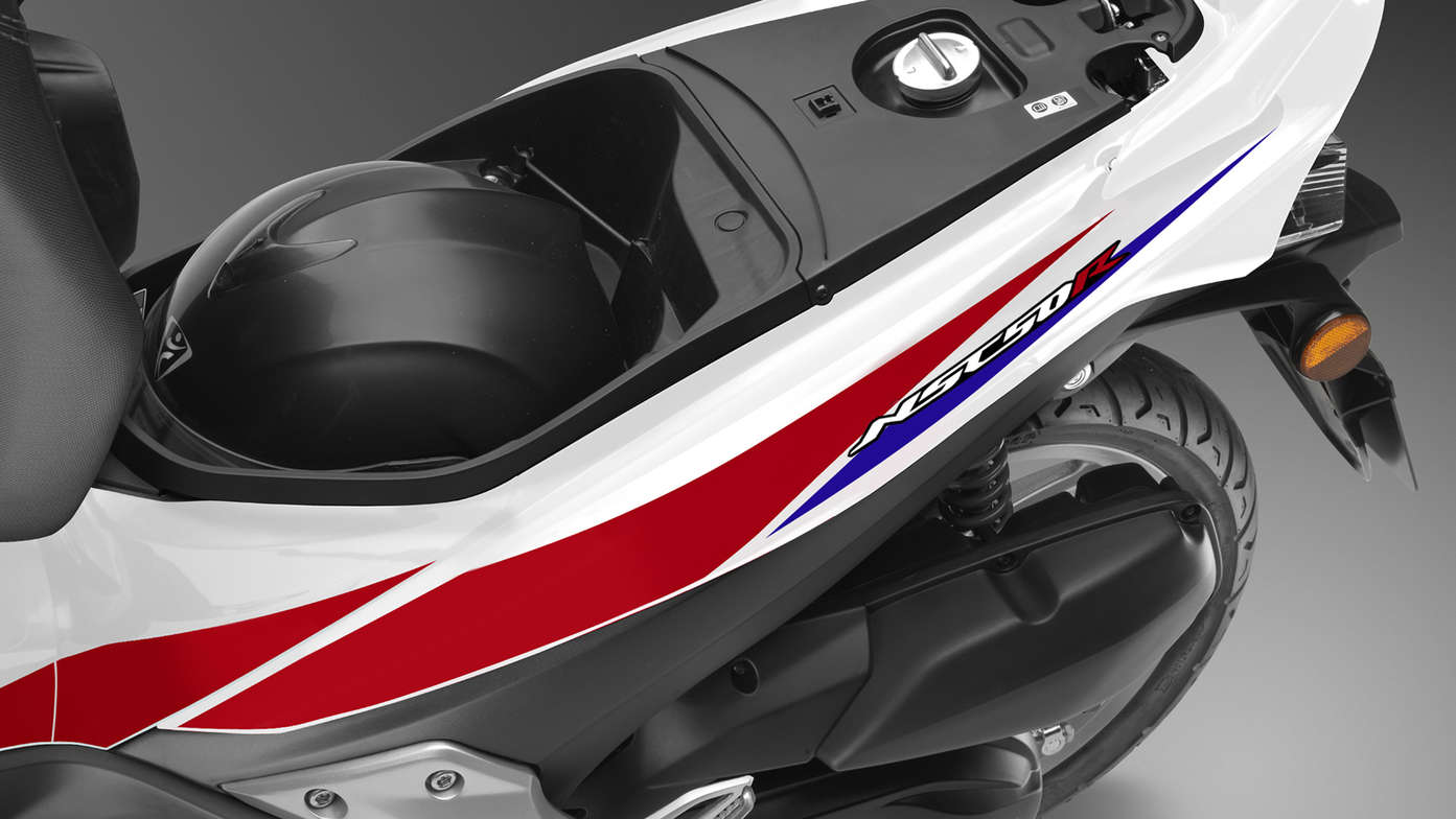 Aerial view of open under-seat storage. Helmet inside.