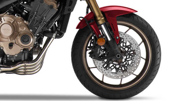 Dual, radial-mount four-piston calipers grip 310mm floating discs, complemented by a single-piston rear caliper and 240mm disc