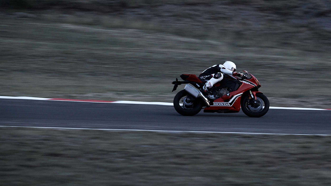 Side facing Honda CBR1000RR with rider on track.