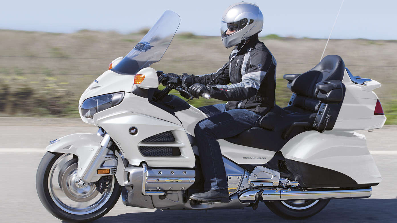 Side shot, white Honda gold wing with rider. 